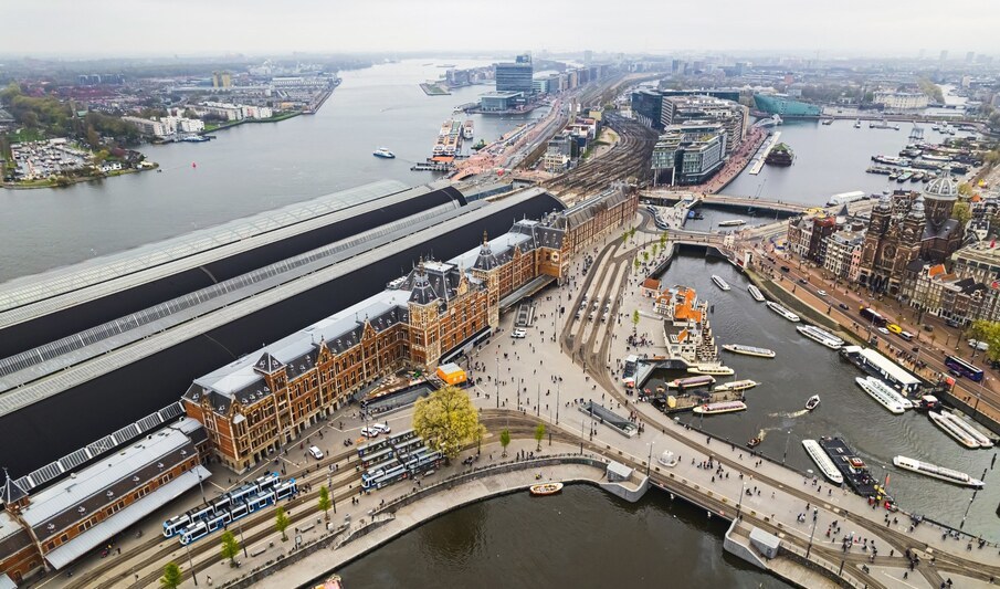Amsterdam Central Station main train station is the real heart of the city: central not only by the name, but also as the biggest public transport transfer spot, drone shot. High quality photo