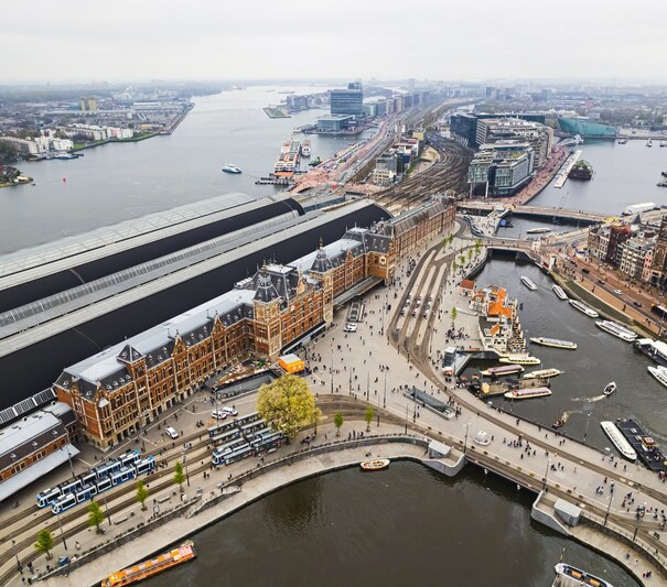 Amsterdam,Central,Station,Main,Train,Station,Is,The,Real,Heart Amsterdam Central Station main train station is the real heart of the city: central not only by the name, but also as the biggest public transport transfer spot, drone shot. High quality photo