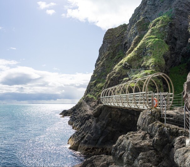 View,Onto,Famous,Bridge,System,(also,Tubular,Bridge),Attached,To View onto famous bridge system (also Tubular Bridge) attached to the coastal rocks above the oceaninc water and Atlantic Ocean coastline along Gobbins Cliff Face Path, Ireland